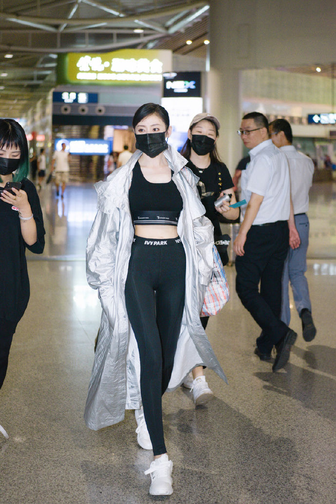 张天爱现身机场 黑色紧身裤外搭银色长款雨衣