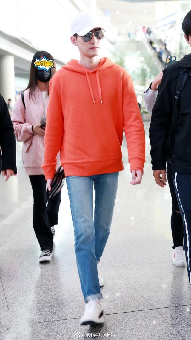 张翰穿橙色卫衣搭配牛仔裤现身机场帅气十足,