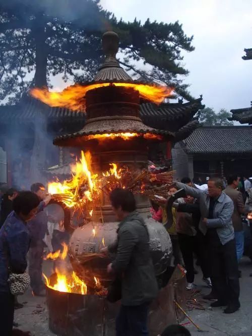 到寺庙门口,便被呛得直咳嗽, 走近一看, 原来寺庙前的香炉插满了高香