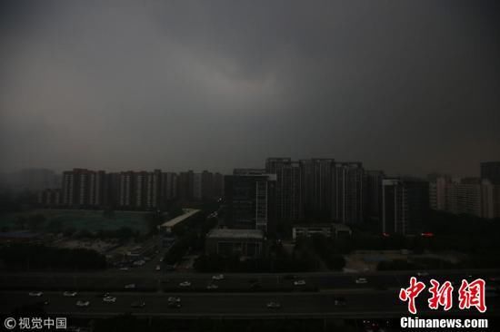 北京迎入夏后最大阵雨 民众雨中出行