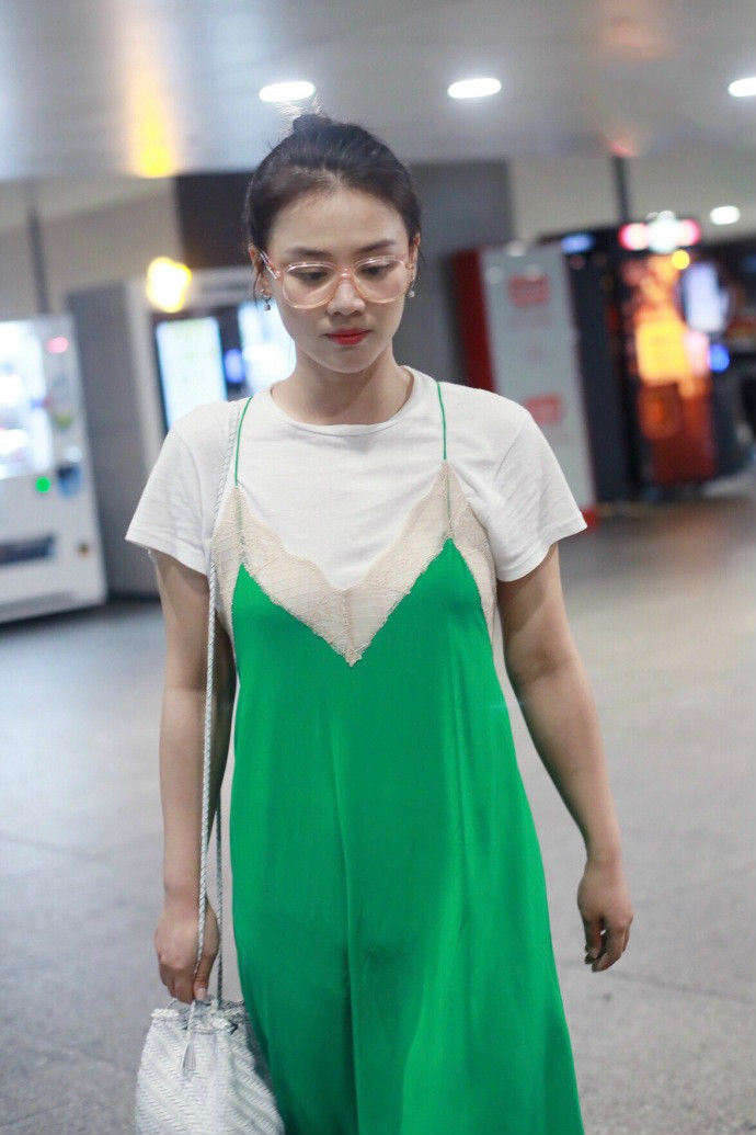 马思纯戴眼镜穿白T恤搭配绿色吊带裙现身机场