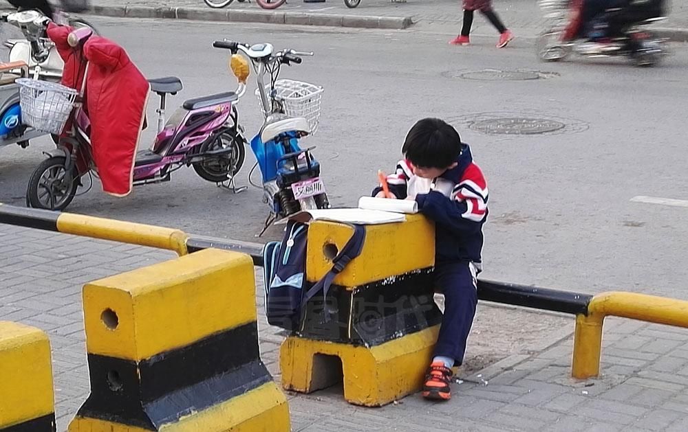 学霸是这样炼成的!寒冬里在校门口写作业等家