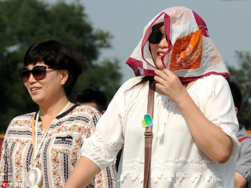 北京直飙35℃高温 大妈丝巾防晒变村姑