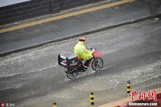 北京迎入夏后最大阵雨 民众雨中出行