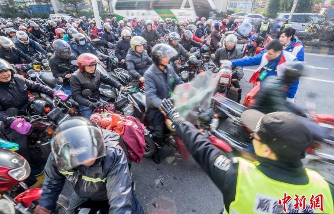 千里返乡的摩托大军：塑料纸绑腿胶带防风，骑行者路边烤火取暖